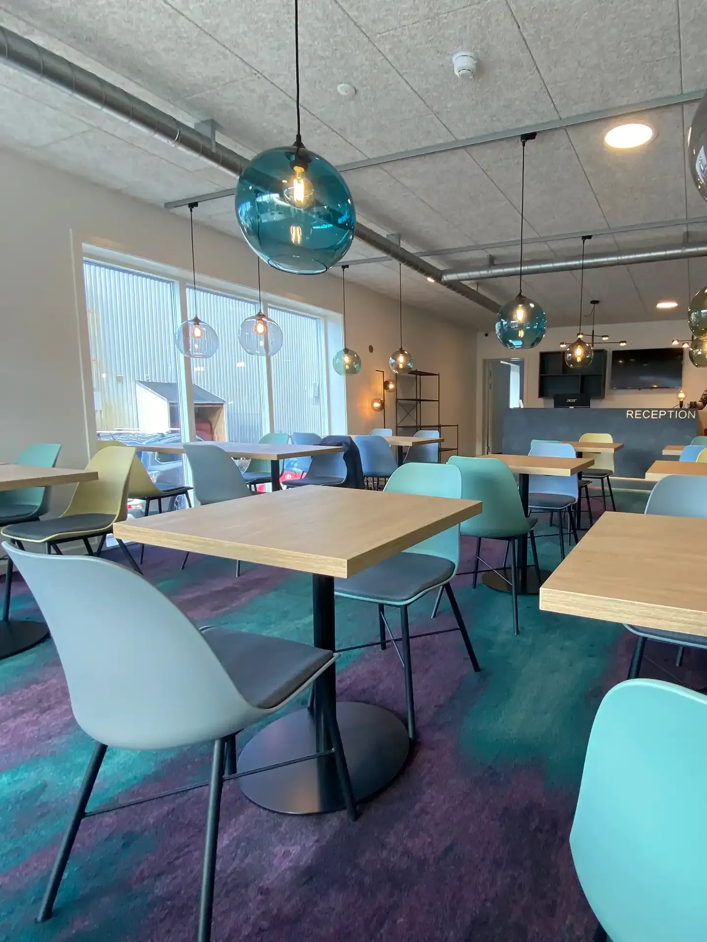 Hotel breakfast room designed by Third.space with modular tables, colourful chairs and lighting inspired by aurora