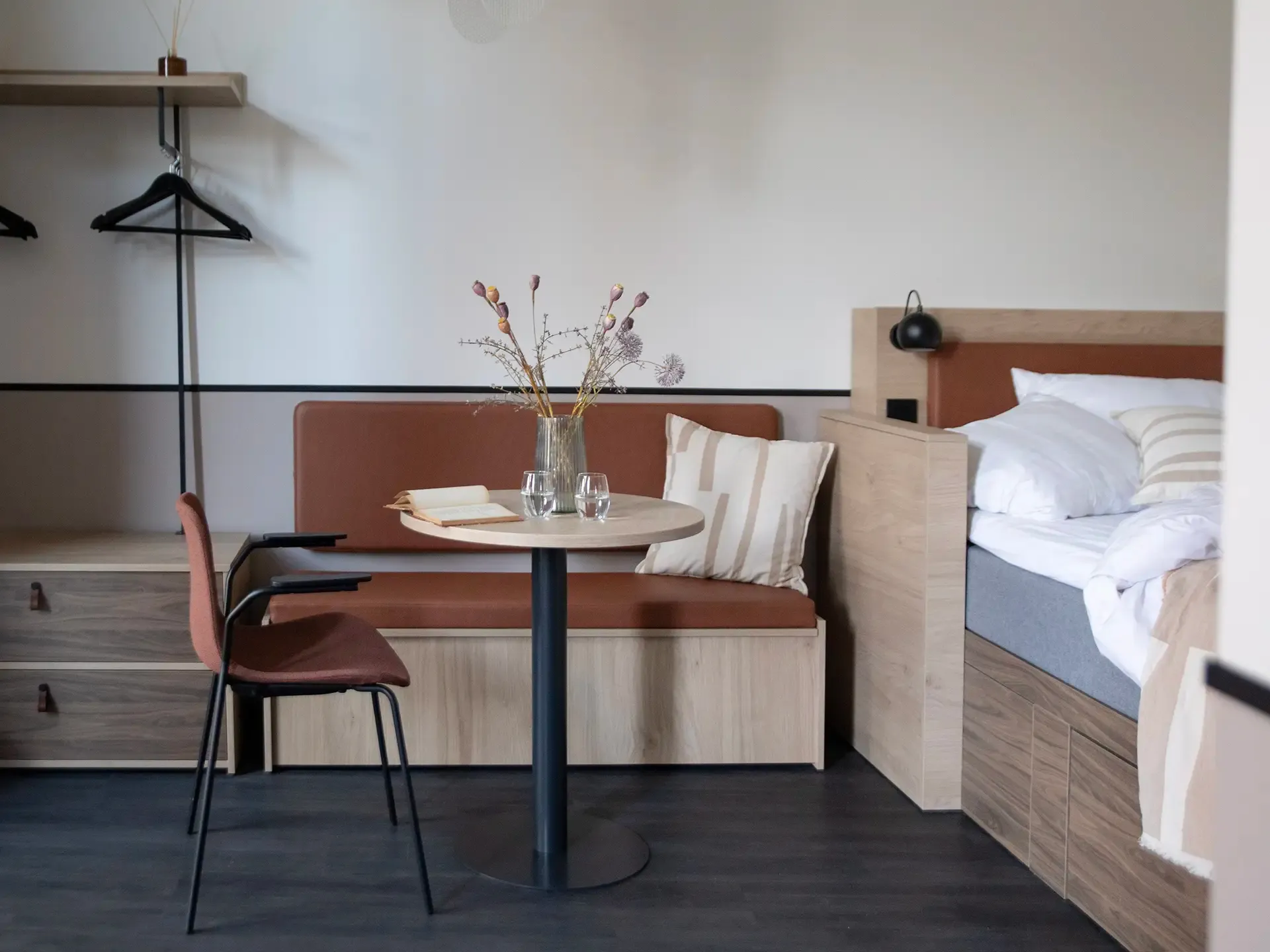 Cozy short-stay apartment with integrated bedroom and dining corner, designed to optimize space and guest comfort in hospitality projects.