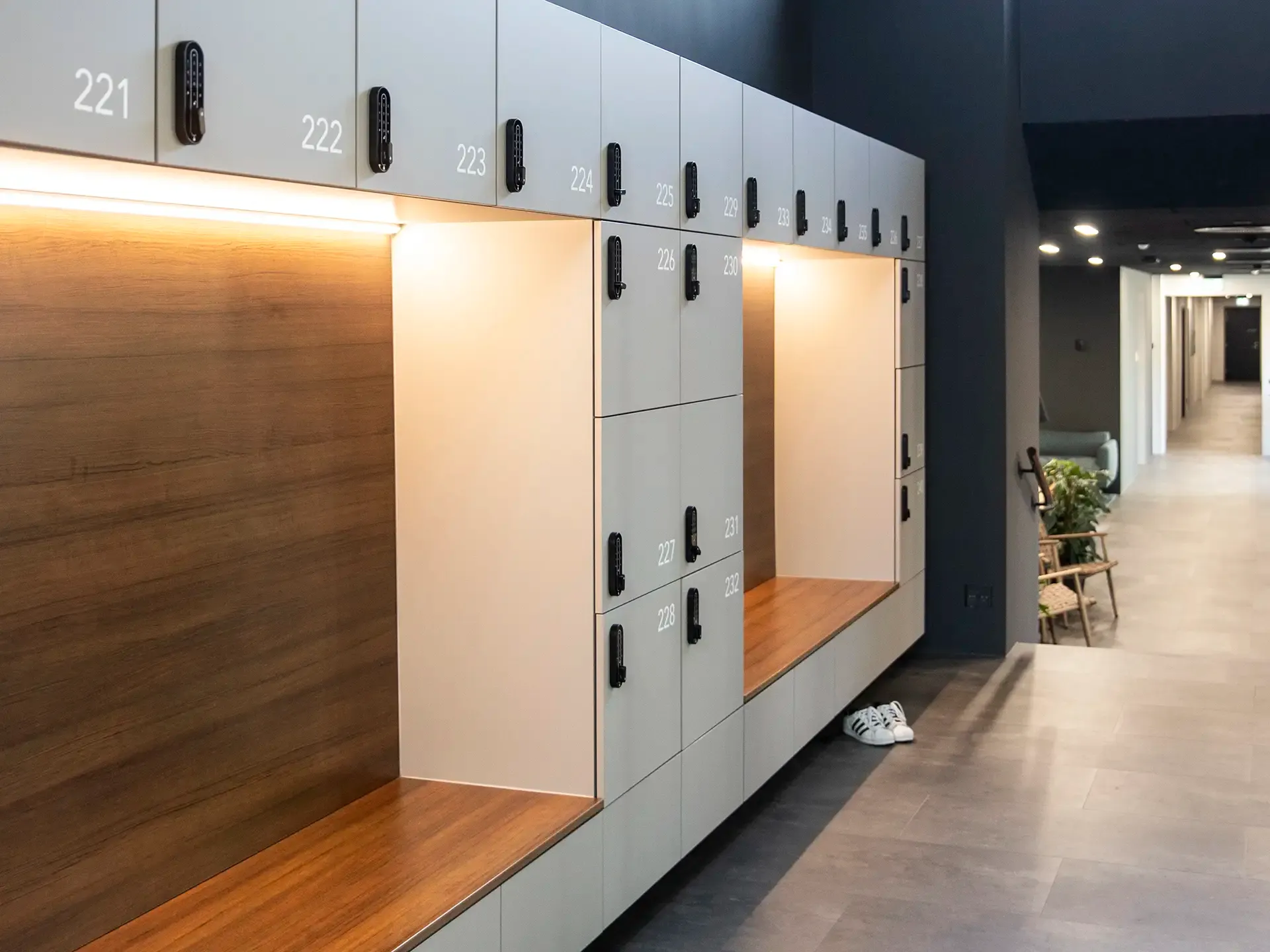 Wall-mounted lockers with built-in bench and soft lighting, designed for seamless functionality in fitness and clinic interiors.