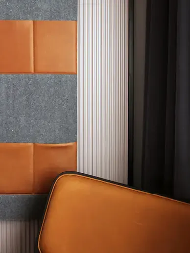 Fully furnished hotel room with custom-made furniture and wall panels in soft wood tones and graphic layout.