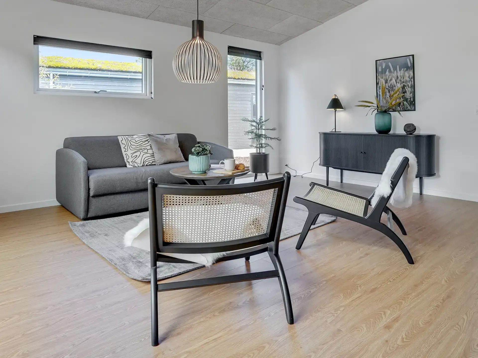 Golf cabin interior design. Living room with black lounge chairs coffee table grey sofa.