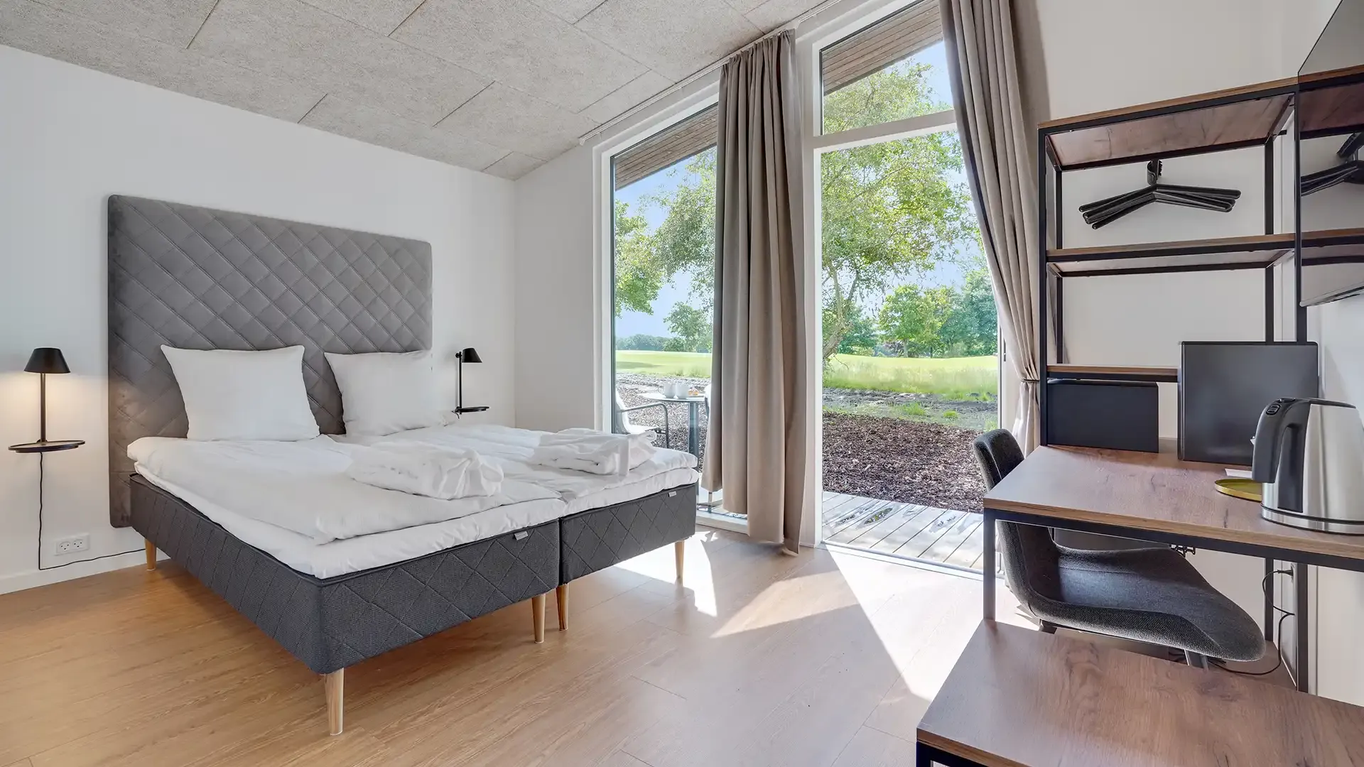 Golf lodge bedroom with double bed, desk, and shelving