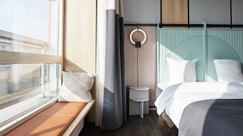 Hotel room with bespoke furniture, soft materials, and Nordic-inspired color palette.