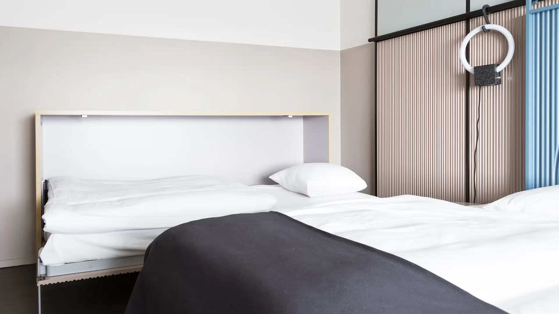Foldaway bed in hotel room with minimalist design