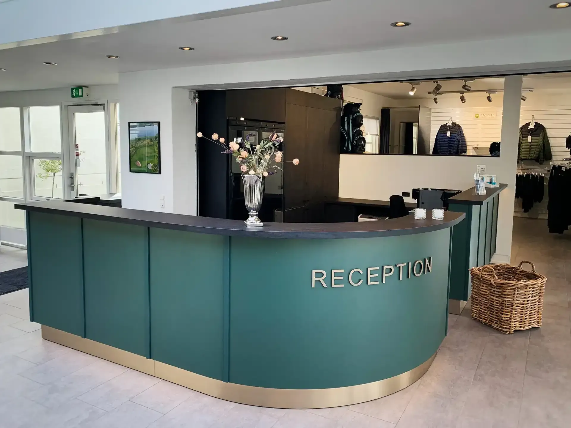 Bespoke green reception desk with brass letters at Royal Oak Golf Club
