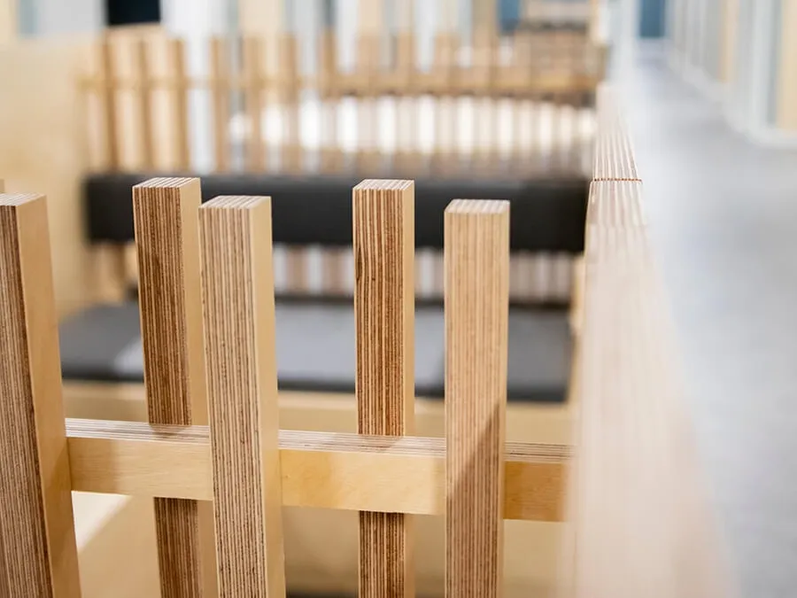 Detail of oak wooden furniture with vertical slats, designed for contemporary student accommodations.