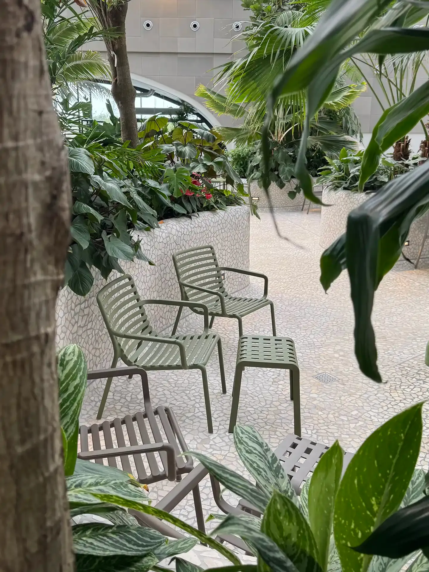 Poolside seating area at Nordborg Resort featuring robust chlorine-resistant chairs and natural planting.