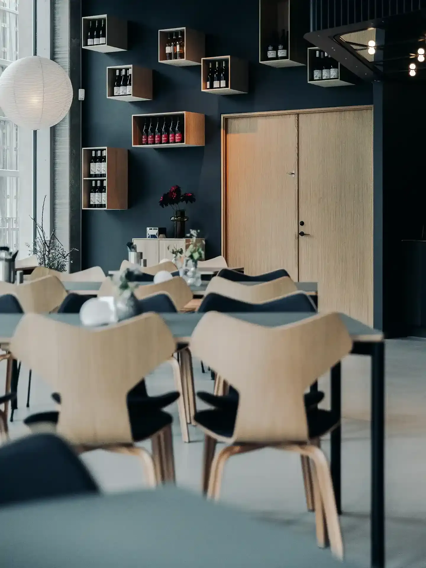 Scandinavian-style restaurant interior with deep blue accents and light oak furniture, tailored for warm yet sophisticated guest experiences.